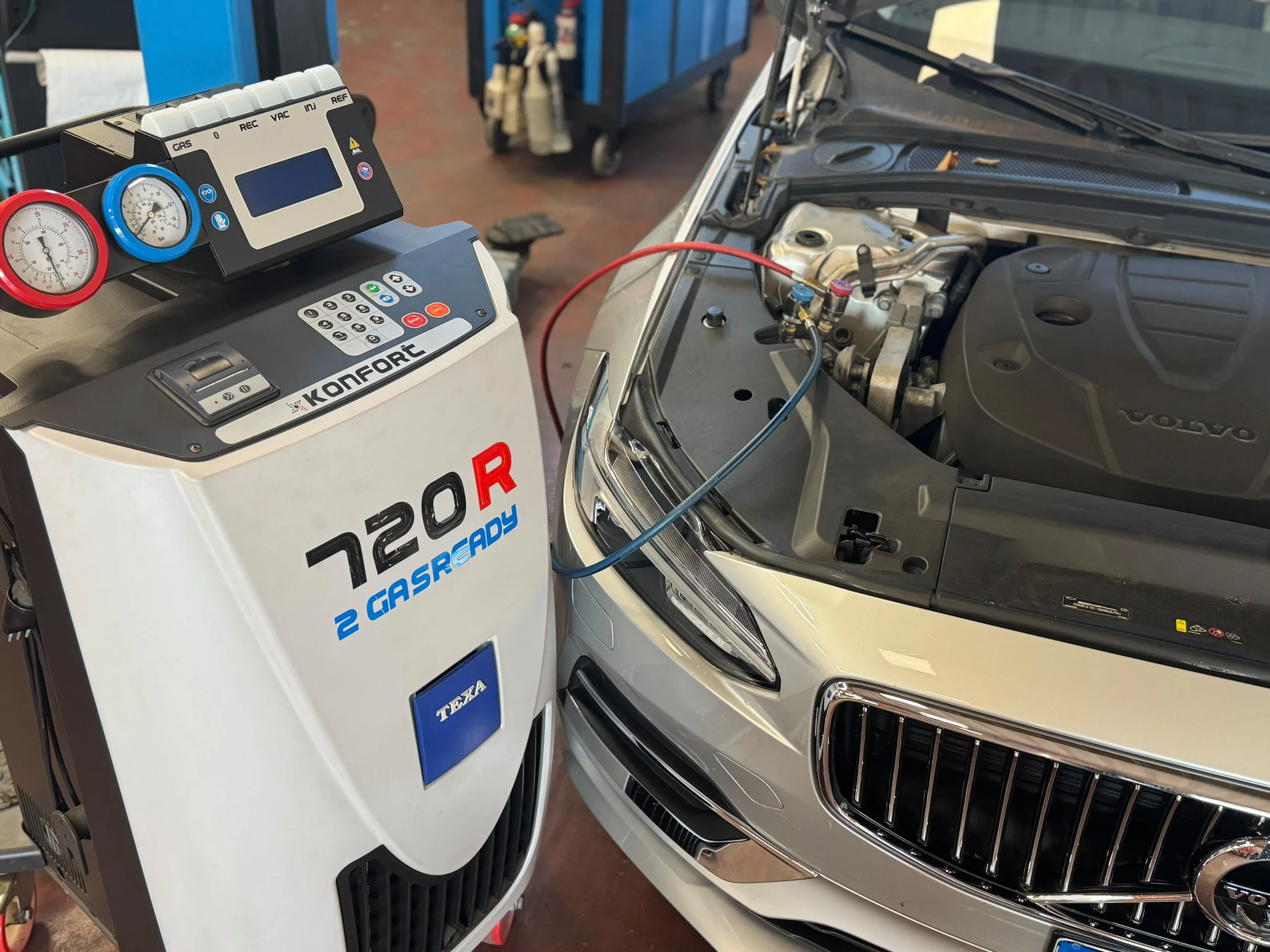 Stazione di ricarica del climatizzatore collegata a un’auto in officina